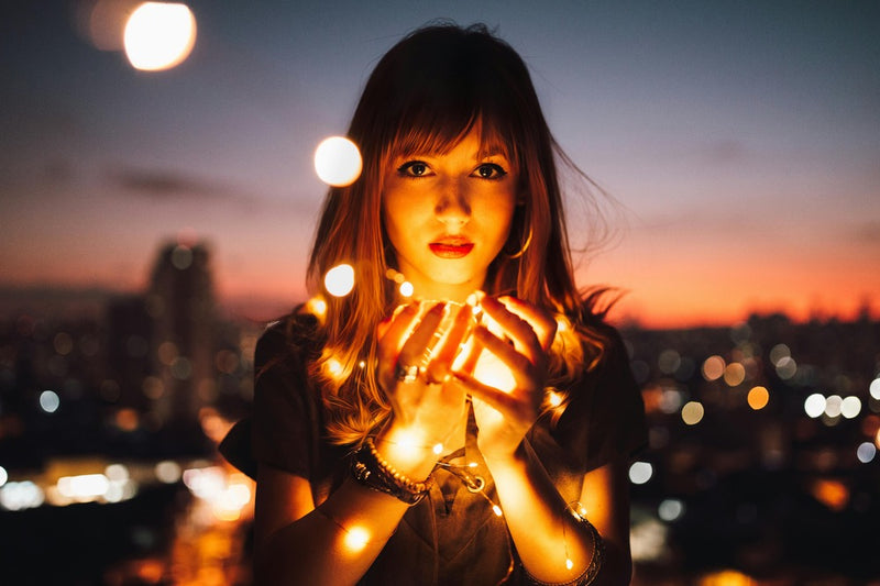 Women holding fireflies in her hand.