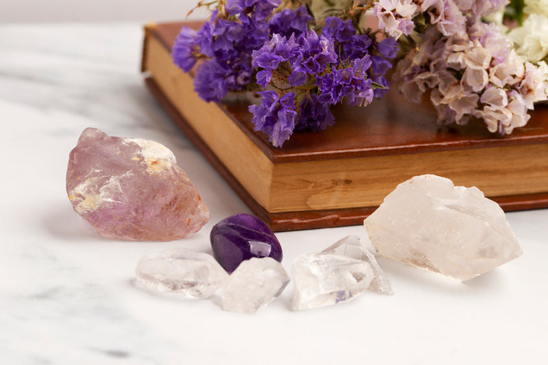 Several crystals are scattered near a book. These crystals are recommended for love and marriage.