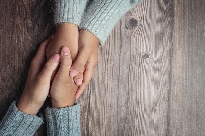 Two people holding hands with kindness and empathy.