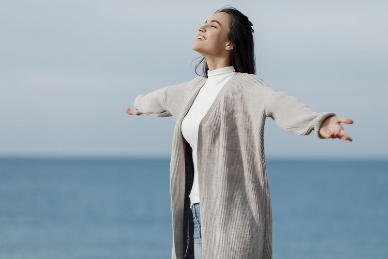 Cover picture of a woman with her arms outstretched looking out at the sky.