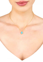 A model wears the Hamsa Opalite Turquoise Blue Gold Necklace around her neck. The necklace length is 40cm with 5cm adjuster to be worn short or long.