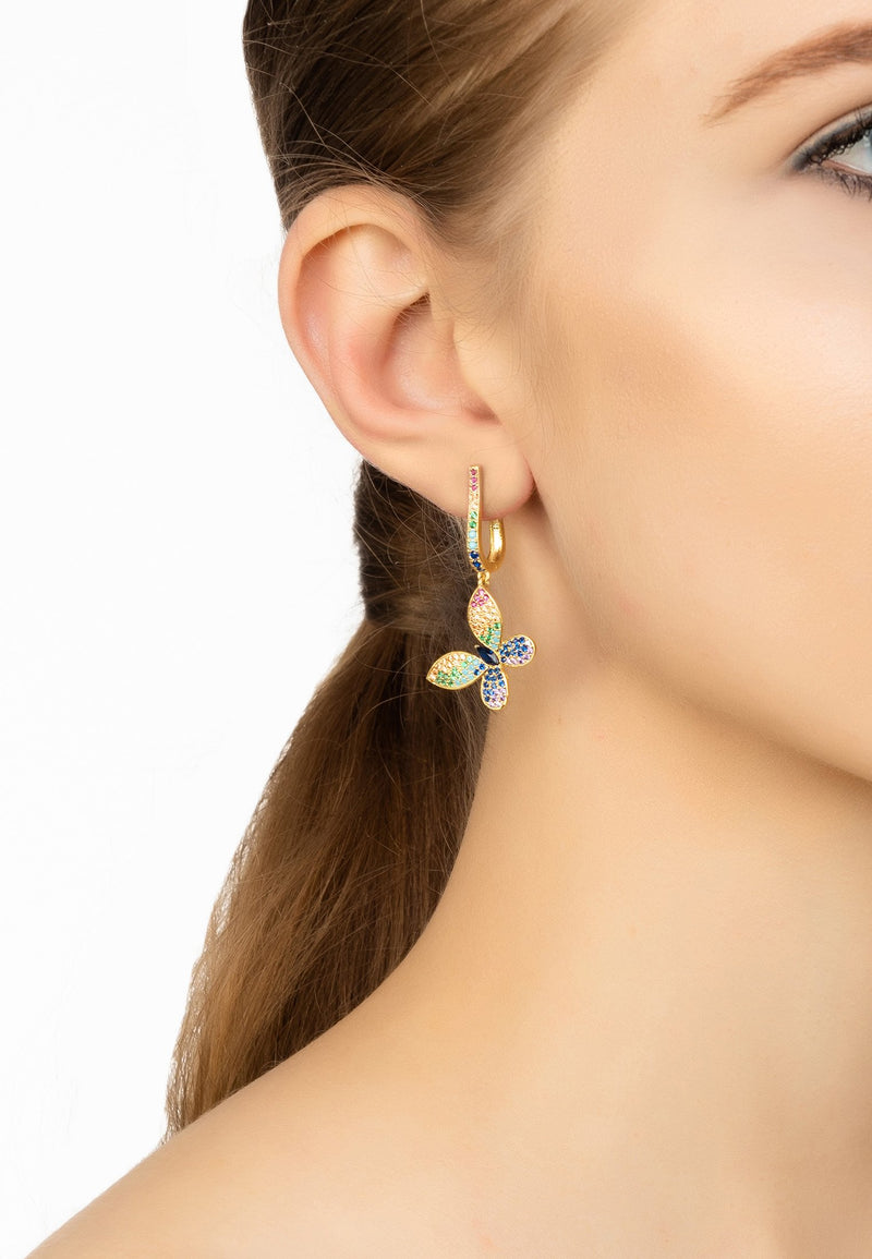 Model wears Multicoloured butterfly drop earrings in gold.