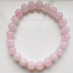 A close up of the Rose Quartz crystal bracelet against a clear background.