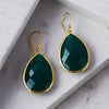 Petite Drop Earring Green Onyx Gold against a marble background.